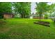 Spacious backyard with lush grass, mature trees, and raised garden beds at 2567 Mona Ave, Charleston, SC 29414