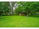 Large backyard with a shed, mature trees, fire pit, and lush lawn at 2567 Mona Ave, Charleston, SC 29414