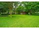 Large backyard with mature trees, lush green grass, and shed at 2567 Mona Ave, Charleston, SC 29414