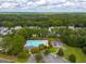 An aerial shot of a neighborhood with a community pool, playground, and surrounded by lush trees at 261 Sweet Alyssum Dr, Ladson, SC 29456