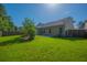 Well-maintained backyard featuring a lush lawn, mature trees, and a patio at 261 Sweet Alyssum Dr, Ladson, SC 29456