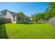Spacious backyard featuring green grass, vinyl siding, trimmed windows, and a wooded view at 261 Sweet Alyssum Dr, Ladson, SC 29456