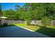 A fully fenced-in backyard with healthy grass, mature trees and a concrete patio at 261 Sweet Alyssum Dr, Ladson, SC 29456