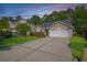 Inviting home with a manicured front lawn, mature shrubs, and a convenient two-car garage at 261 Sweet Alyssum Dr, Ladson, SC 29456