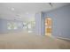 Spacious living room featuring large windows, neutral carpet, and an open layout at 261 Sweet Alyssum Dr, Ladson, SC 29456