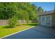 Enclosed back patio that features a lush lawn, mature trees, and a concrete patio at 261 Sweet Alyssum Dr, Ladson, SC 29456