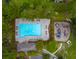A top-down view of a community pool area featuring ample seating, a playground, and mature trees at 261 Sweet Alyssum Dr, Ladson, SC 29456