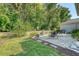 Lush backyard featuring a stone patio, manicured lawn, mature trees and a privacy fence at 2652 Private Lefler Dr, Johns Island, SC 29455