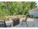 Backyard featuring a stone patio with seating area, fire pit, grill, and lush green landscaping at 2652 Private Lefler Dr, Johns Island, SC 29455