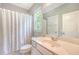 Bright bathroom featuring a shower with curtain, toilet, and a vanity with a large mirror at 2652 Private Lefler Dr, Johns Island, SC 29455