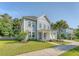 Charming two-story home with a manicured lawn and inviting front porch, enhanced by lush greenery at 2652 Private Lefler Dr, Johns Island, SC 29455
