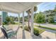 Relaxing front porch view with cushioned chairs, elegant columns, and a serene neighborhood setting at 2652 Private Lefler Dr, Johns Island, SC 29455