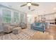 Cozy living room with kitchen view, showcasing hardwood floors, large windows and stylish furniture at 2652 Private Lefler Dr, Johns Island, SC 29455