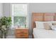Bright bedroom featuring natural light, a wooden bed frame, and a plant-accented nightstand at 2802 Cavalcade Cir, Johns Island, SC 29455