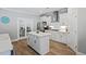 Bright kitchen features white cabinets, stainless steel appliances and a center island with wood flooring at 2802 Cavalcade Cir, Johns Island, SC 29455