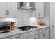 Close up of the kitchen appliances with a stainless steel vent hood, gas cooktop and white subway tile backsplash at 2802 Cavalcade Cir, Johns Island, SC 29455