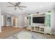 Open living room with wood floors, TV and storage space, and a ceiling fan at 2802 Cavalcade Cir, Johns Island, SC 29455