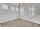 Well-lit dining room with carpet, three windows, stylish chandelier, and classic wainscoting for elegant meals at 2820 Merriams Dr, Charleston, SC 29414