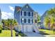 Two-story home with a driveway, garage, and a welcoming front porch under a blue sky with palm trees at 2820 Merriams Dr, Charleston, SC 29414