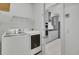 Bright laundry area with white front-load machines and wire shelving, open to gray kitchen at 2820 Merriams Dr, Charleston, SC 29414