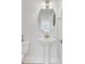 Modern powder room featuring a pedestal sink, oval mirror, and stylish lighting fixtures with neutral tones at 2820 Merriams Dr, Charleston, SC 29414