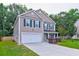 Charming two-story home with a white garage door, green shutters, and a well-manicured front yard at 3009 Mapleleaf Dr, Moncks Corner, SC 29461