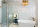 A luxurious bathroom featuring marble walls, a soaking tub, and a glass-enclosed shower with gold fixtures at 3023 Eventide Dr, Johns Island, SC 29455