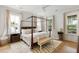 Serene bedroom with a canopy bed, hardwood floors, and natural light from surrounding windows at 3023 Eventide Dr, Johns Island, SC 29455
