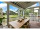 Covered porch with dining table and comfortable chairs overlooking a scenic view at 3023 Eventide Dr, Johns Island, SC 29455