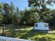 Spacious backyard featuring a shed, a swing and a basketball hoop surrounded by lush trees at 304 Carolina Cir, Walterboro, SC 29488