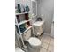 Neutral toned bathroom featuring a toilet, sink, storage rack and a variety of toiletries at 304 Carolina Cir, Walterboro, SC 29488