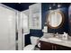Bathroom features a glass enclosed shower, dark blue walls, and a decorative round mirror at 308 Oak Park St, Summerville, SC 29486