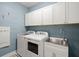 Well-lit laundry room featuring a washer, dryer, sink, and white cabinets for ample storage at 308 Oak Park St, Summerville, SC 29486