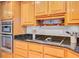 Close up of a kitchen featuring wood cabinetry, black granite countertops, and an induction cooktop at 310 Christiee Ct, North Charleston, SC 29418