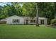 Charming one-story home with lush lawn, mature trees, and inviting painted brick facade at 3231 Stonehaven Dr, North Charleston, SC 29420