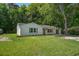 Charming, renovated single-story home with white painted brick, green shutters and surrounded by mature trees at 3231 Stonehaven Dr, North Charleston, SC 29420