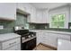Bright kitchen with white cabinets, modern backsplash, and stainless steel appliances at 3231 Stonehaven Dr, North Charleston, SC 29420