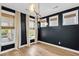 Stylish dining area with dark walls, decorative lighting, light wood floors and multiple large windows at 327 Megans Bay Ln, Charleston, SC 29492