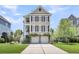 Beautiful two-story home featuring double garage, charming balconies, and a well-manicured lawn at 327 Megans Bay Ln, Charleston, SC 29492