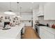 Spacious kitchen features white cabinets, stainless steel appliances, and a cozy fireplace in the adjacent living area at 3285 Johnstowne St, Johns Island, SC 29455