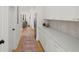A well-lit hallway featuring white cabinets and modern appliances at 3285 Johnstowne St, Johns Island, SC 29455