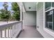 Spacious front porch with neutral gray flooring and white pillars at 3408 Salterbeck St, Mount Pleasant, SC 29466