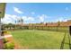 Expansive backyard featuring lush green grass, landscaping, and a secure black fence at 350 Dahlia Row Dr, Summerville, SC 29486