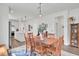 Warm dining area with wooden table set for six and white kitchen island nearby at 350 Dahlia Row Dr, Summerville, SC 29486