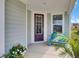 Charming front porch with a cozy bench, complemented by colorful flowers and lush greenery, and a window at 350 Dahlia Row Dr, Summerville, SC 29486