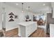 Open kitchen layout with center island, stainless appliances, and seamless flow into dining and living areas at 350 Dahlia Row Dr, Summerville, SC 29486