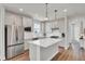 Bright kitchen with white cabinets, stainless steel appliances, and a large island with pendant lighting at 350 Dahlia Row Dr, Summerville, SC 29486