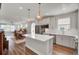 Open-concept kitchen with a large island, stainless steel appliances, and a view of the dining and living area at 350 Dahlia Row Dr, Summerville, SC 29486
