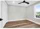 Neutral bedroom with hardwood floors, ceiling fan, closet, and bright window showing neighborhood views at 397 Parkdale Dr, Charleston, SC 29414