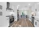 Modern kitchen with white cabinetry, stainless steel appliances, and hardwood floors, flowing into the dining area at 397 Parkdale Dr, Charleston, SC 29414